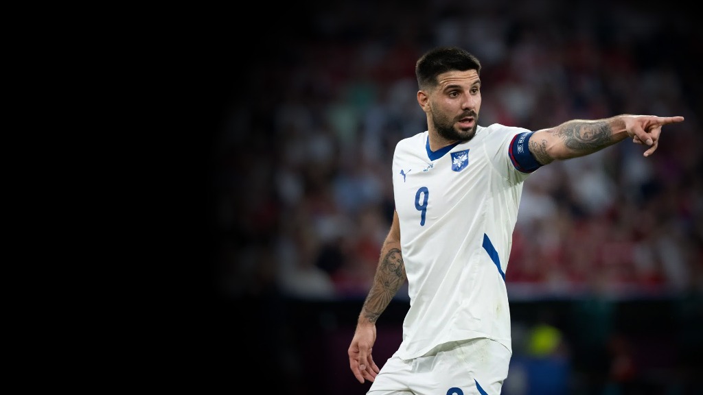 Aleksandar Mitrović in white Serbia kit pointing on the pitch